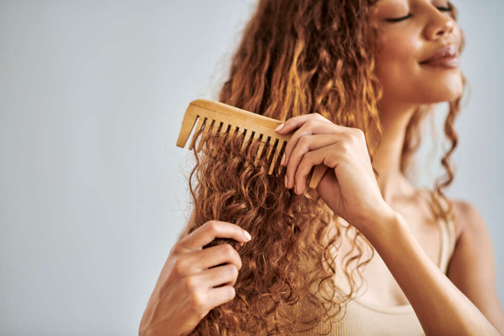 Mulher penteando seu cabelo saudável