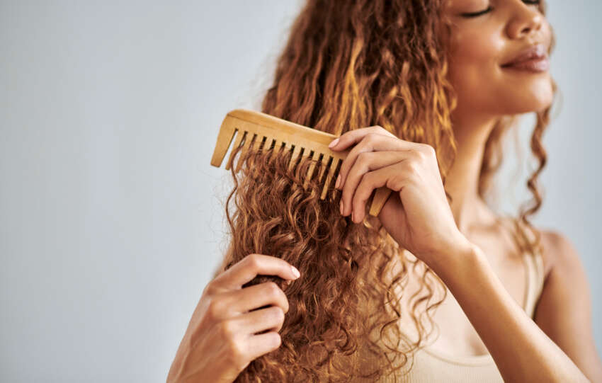 Mulher penteando seu cabelo saudável