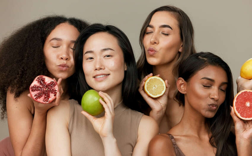 Mulheres com diferentes tons de pele segurando frutas com vitamina C para o cabelo
