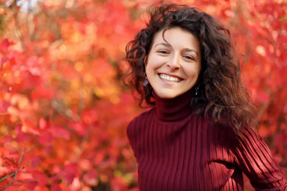 mulher-branca-vestindo-sweater-vermelho-sorrindo-em-um-paque-durante-o-outono