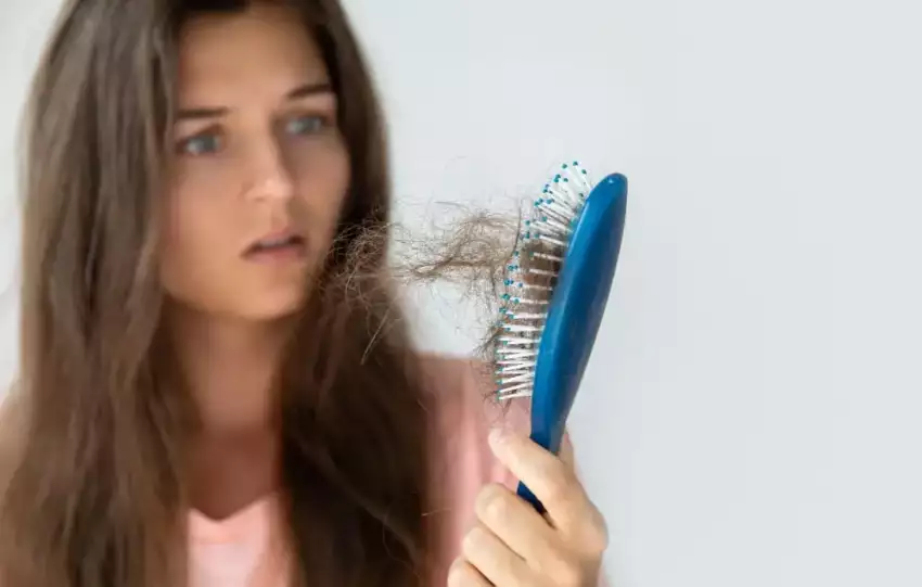 mulher-morena-segurando-uma-escova-de-cabelo-assustada-com-a-quantidade-de-cabelo-que-ficou-na-escola-apos-escovar-seu-cabelo